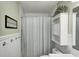 A serene bathroom featuring a shower with a striped curtain, a mirrored cabinet, and charming wall decor at 1910 Riverstone Ct, Westfield, IN 46074