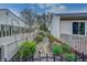 Charming side yard featuring a stone walkway, vibrant flower beds, and a decorative wrought iron fence at 1910 Riverstone Ct, Westfield, IN 46074