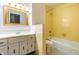 Retro yellow bathroom with white vanity, sink, and framed mirror, offering a vibrant and unique space at 2141 Rome Dr # Apt B, Indianapolis, IN 46228