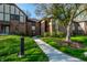 Brick condominium exterior featuring a walkway, green space, mature tree, and manicured landscaping at 2141 Rome Dr # Apt B, Indianapolis, IN 46228