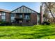 Back exterior view showing the brick building and grassy backyard with privacy fences and mature trees at 2141 Rome Dr # Apt B, Indianapolis, IN 46228