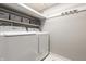 Bright laundry area featuring a modern white washer and dryer setup with storage shelves, maximizing space and efficiency at 2141 Rome Dr # Apt B, Indianapolis, IN 46228