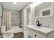 Bright bathroom featuring marble tile, white vanity, toilet, and shower with bathtub combination at 222 Raines St, Plainfield, IN 46168