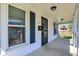 The front porch of this charming home features white pillars, black railings, and a decorative security door at 222 Raines St, Plainfield, IN 46168