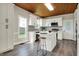Bright kitchen featuring white cabinets, stainless steel appliances, an island, and a unique wood ceiling at 222 Raines St, Plainfield, IN 46168