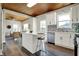 Bright, open concept kitchen with white cabinets and an island, leading into the living room at 222 Raines St, Plainfield, IN 46168