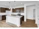 Modern kitchen featuring a white center island, stainless steel appliances, and dark wood cabinets at 2249 Aviary Ln, Danville, IN 46122