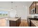 Bright, open kitchen features an island, stainless appliances, and wood cabinets and floors at 2249 Aviary Ln, Danville, IN 46122