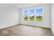 Bright living room featuring large windows with scenic backyard views and wood-look flooring at 2249 Aviary Ln, Danville, IN 46122