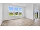 Bright living room featuring large windows with scenic backyard views and wood-look flooring at 2249 Aviary Ln, Danville, IN 46122