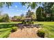 Backyard with a stone fire pit surrounded by landscaping, mature trees, and a cozy, inviting atmosphere at 2253 Mullinix Rd, Greenwood, IN 46143