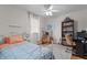 Bright bedroom features a ceiling fan, a large window, and a workspace with a bookshelf at 2253 Mullinix Rd, Greenwood, IN 46143