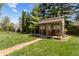 Charming outbuilding with a porch and seating, nestled in a lush backyard with a gravel path at 2253 Mullinix Rd, Greenwood, IN 46143