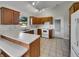 Clean kitchen with white countertops, appliances, and wooden cabinets, offering a functional layout at 2338 Keystone Ct, Anderson, IN 46011