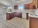 A kitchen with ample counter space, wooden cabinets, tile floor, and a view from a large window at 2338 Keystone Ct, Anderson, IN 46011