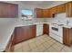 Traditional kitchen with wood cabinets, white countertops, and tile flooring providing a functional cooking space at 2338 Keystone Ct, Anderson, IN 46011