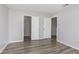 Bedroom with two closet doors, a large window, and gray wood flooring at 2348 Shadowbrook Dr, Plainfield, IN 46168