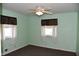Bedroom features neutral carpet, seafoam green walls, and a ceiling fan for added comfort at 2726 S Roena St, Indianapolis, IN 46241