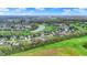 Bird's eye view of a residential area with beautiful houses bordering a green golf course, pond, and blue sky at 284 Chatham Hills Blvd, Westfield, IN 46074