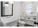A bright white bathroom with a unique sink, classic fixtures, and built-in shelving under a window at 284 Chatham Hills Blvd, Westfield, IN 46074