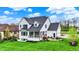 Landscaped backyard with fire pit and patio of a modern white home with a walkout and balcony at 284 Chatham Hills Blvd, Westfield, IN 46074