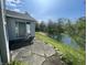 This backyard features a serene pond view, stone patio, and sliding glass door access to the home at 2904 Inverrary Ct, Indianapolis, IN 46234