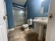 Bathroom with blue walls, pedestal sink, tile floor, and shower with glass door at 2904 Inverrary Ct, Indianapolis, IN 46234