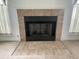 Close-up of a fireplace featuring tile work and a metallic mesh enclosure in a neutral color scheme at 2904 Inverrary Ct, Indianapolis, IN 46234