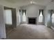 Bright living room featuring a fireplace, neutral carpet, and elegant draperies and access to other rooms at 2904 Inverrary Ct, Indianapolis, IN 46234