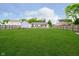 Spacious backyard with lush green lawn, wooden fence, and view of the home's exterior and additional building at 324 Palmyra Dr, Indianapolis, IN 46239