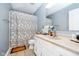 Well-lit bathroom featuring modern fixtures, vanity with ample storage, and a shower with patterned curtain at 324 Palmyra Dr, Indianapolis, IN 46239