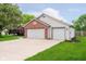Single-Gathering home featuring a well-maintained lawn, two-car garage, and brick accents at 324 Palmyra Dr, Indianapolis, IN 46239