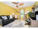 Bright living room featuring wood-look ceiling fan, sofa, and a dedicated work space with desk at 324 Palmyra Dr, Indianapolis, IN 46239