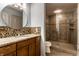 Modern bathroom equipped with a glass-enclosed shower, granite countertop, and a stylish round mirror at 333 Massachusetts Ave # 204, Indianapolis, IN 46204