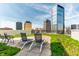Scenic rooftop terrace featuring lounge chairs, lush greenery, and a beautiful view of surrounding skyscrapers at 333 Massachusetts Ave # 204, Indianapolis, IN 46204