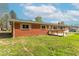 Backyard view of brick home with wooden porch and an unkempt lawn at 3362 E Sycamore Ln, Mooresville, IN 46158