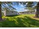Expansive backyard with lush green grass, mature trees, and detached garage at 3561 Winings Ave, Indianapolis, IN 46221