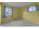 This bedroom has light walls, neutral carpet, and two windows at 3561 Winings Ave, Indianapolis, IN 46221