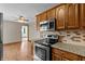 Well-lit kitchen featuring stainless steel appliances and wood cabinets at 3561 Winings Ave, Indianapolis, IN 46221
