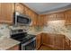 Up close of well-lit kitchen featuring stainless steel appliances, wood cabinets, and light countertops at 3561 Winings Ave, Indianapolis, IN 46221