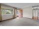 Neutral carpeted living room featuring a bright window and an exterior door at 3561 Winings Ave, Indianapolis, IN 46221