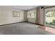Neutral carpeted living room featuring a bright window and an exterior door at 3561 Winings Ave, Indianapolis, IN 46221