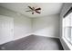 Minimalist bedroom with a ceiling fan, neutral gray walls, dark flooring, and natural light at 360 Neuman Way, Carmel, IN 46032