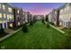 Well-manicured community lawn with views of townhomes at dusk at 360 Neuman Way, Carmel, IN 46032