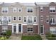 Inviting townhome featuring a mix of brick and siding, complemented by black trim and a charming balcony at 360 Neuman Way, Carmel, IN 46032