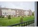 View of townhomes with brick and siding, surrounded by green grass and small trees at 360 Neuman Way, Carmel, IN 46032