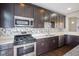Kitchen features stainless steel appliances, stone countertops and backsplash, and modern lighting at 360 Neuman Way, Carmel, IN 46032