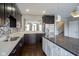Kitchen with stone island, stainless steel appliances, and dark cabinets, accented with modern lighting at 360 Neuman Way, Carmel, IN 46032