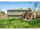 The backyard boasts a manicured lawn, a spacious deck, and a cozy patio area for entertaining at 3615 Dawnwood Dr, Indianapolis, IN 46227