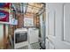 Unfinished basement with laundry machines, washer, dryer, water heater, utility sink, and storage shelves at 3615 Dawnwood Dr, Indianapolis, IN 46227